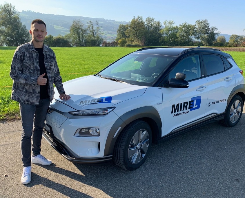 Mirel Turkes steht neben dem Schulauto