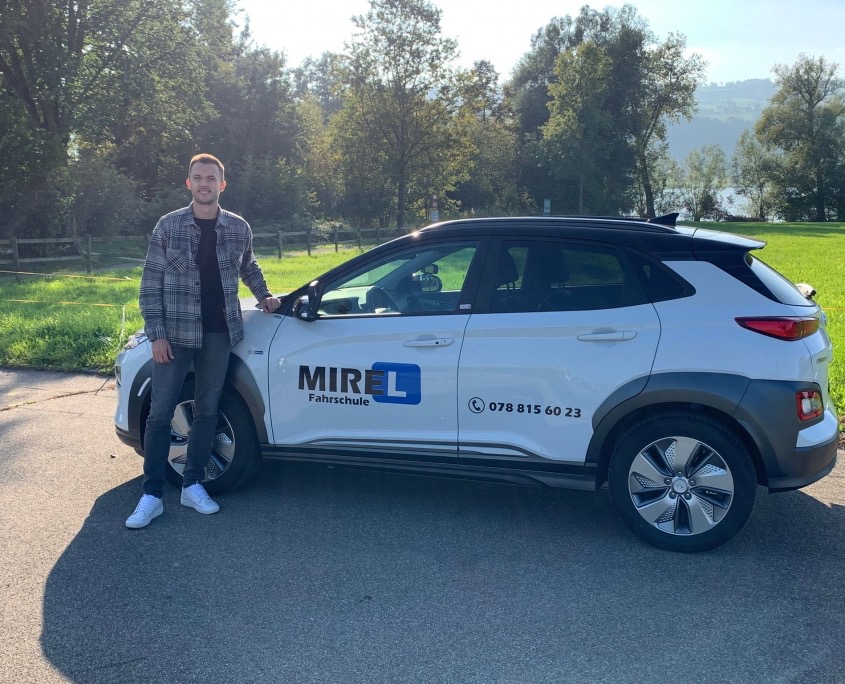 Mirel Turkes lehnt am Schulauto